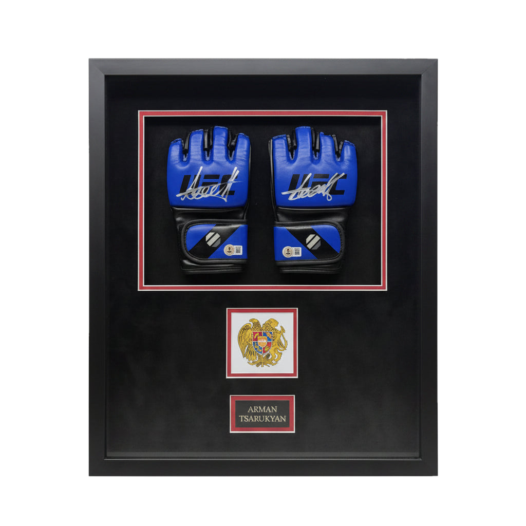A pair of signed blue UFC gloves by Arman Tsarukyan displayed in a black frame with an emblem.