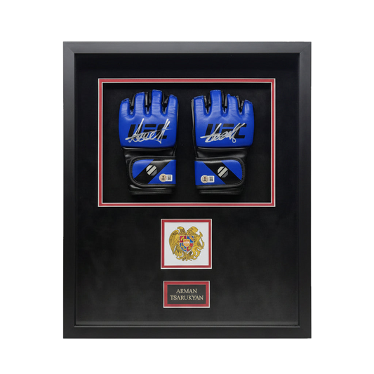A pair of signed blue UFC gloves by Arman Tsarukyan displayed in a black frame with an emblem.