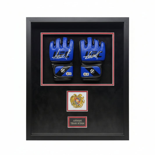 A pair of signed blue UFC gloves by Arman Tsarukyan displayed in a black frame with an emblem.